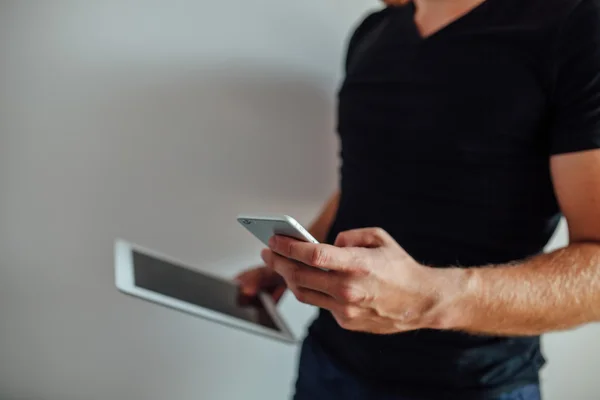 Man använder pc tablet och hålla telefonen. Royaltyfria Stockbilder