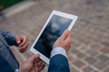 İki şık erkek ile ayakta tablet pc. Yakın çekim.