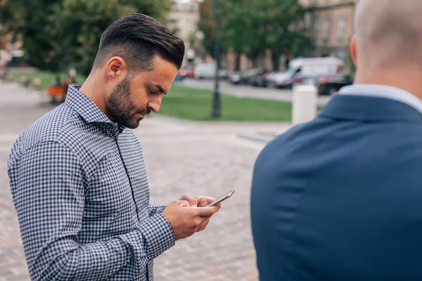 Dwóch mężczyzn elegancki, stojących z telefonu komórkowego. — Zdjęcie stockowe