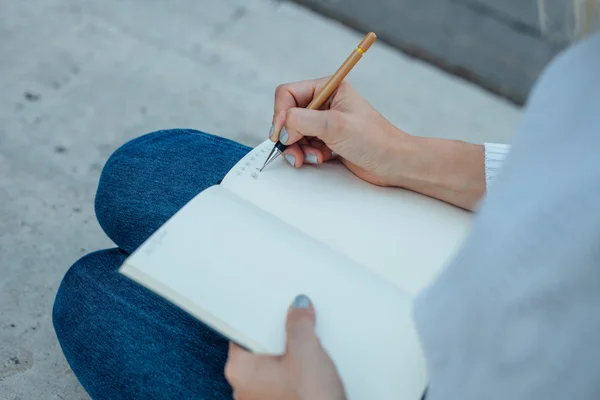 Les mains de la femme dessinent des croquis sur le carnet. Backg extérieur — Photo