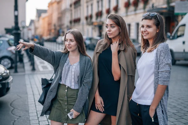 Três meninas estão de pé e olhando para algo na cidade . — Fotografia de Stock