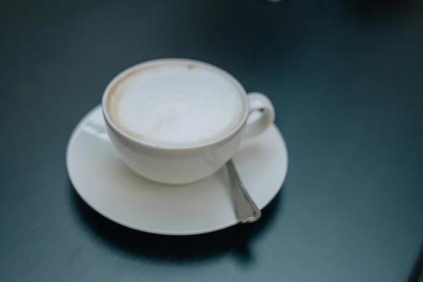 Filiżankę cappuccino na drewnianym stole. — Zdjęcie stockowe