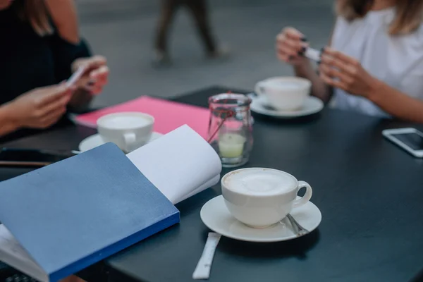 Kopje capuccino en andere dingen van de vergadering op de tafel. Buiten c — Stockfoto