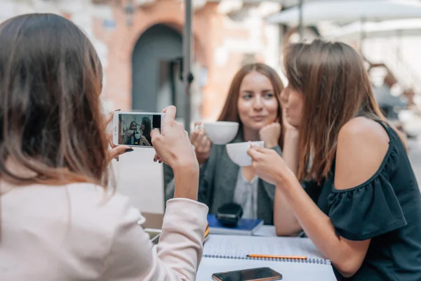 Dos chicas están posando para hacer fotos por su amigo por smartpho —  Fotos de Stock