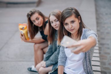 Genç kadın sokak merdiven oturan ve selfie alarak. Şehir