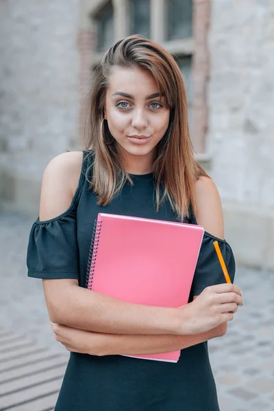 Junge Studentin posiert vor der Kamera und hält einen Stift in der Hand — Stockfoto