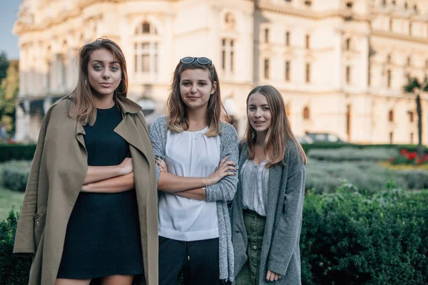 Tre ragazze sono in piedi e in posa per la foto. Città backgro — Foto Stock