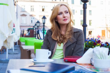 Bir kafede oturan genç zarif kadın