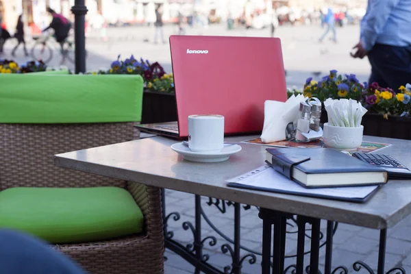 咖啡杯和笔记本电脑放在咖啡桌上 — 图库照片