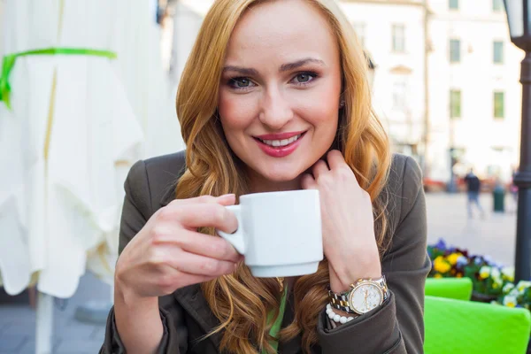 Vrouw zittend in café met kop koffie — Stockfoto