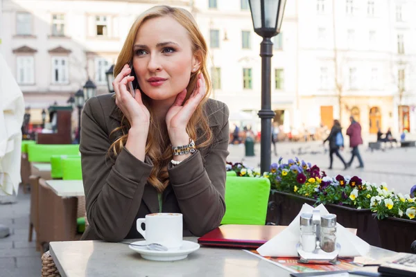 Elegant woman talking by phone in a cafe — Stock Photo, Image