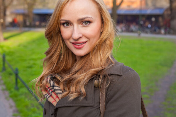 Блондинка прогуливается по улице в городском парке
.