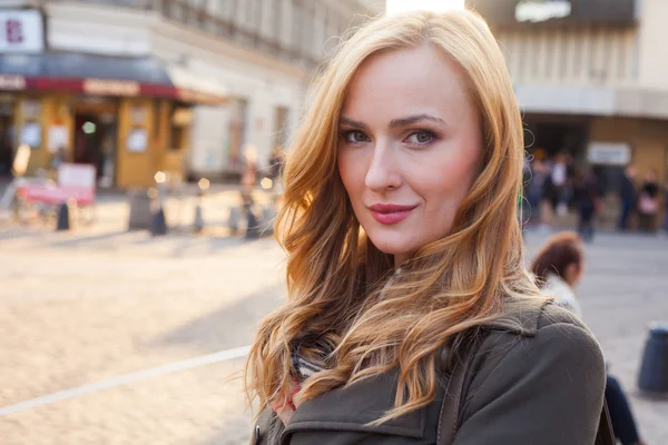 Blonde lopen op de straat in de stad — Stockfoto