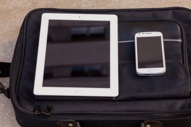 Tablet ve bir çanta üstünde hareket eden telefon