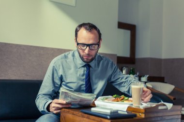 İşadamı okuma gazete kahvaltı sırasında
