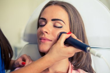 Mikrodermabrazyon yordamı kadın için yapıyor güzellik uzmanı
