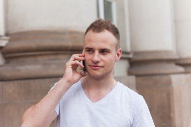 Adam dışarıda telefonla konuşuyor.