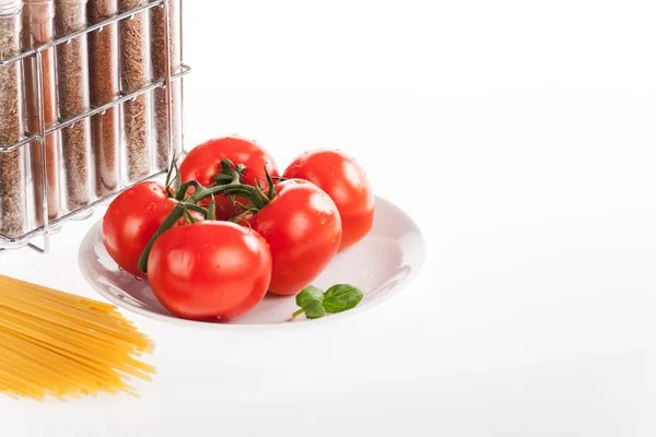 Red tomatoes and ground spices in bottles — Stock Photo, Image