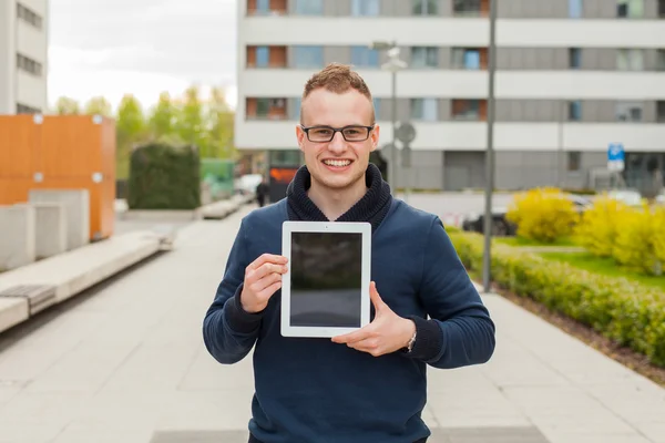 Młody człowiek z komputera typu tablet na ulicy — Zdjęcie stockowe