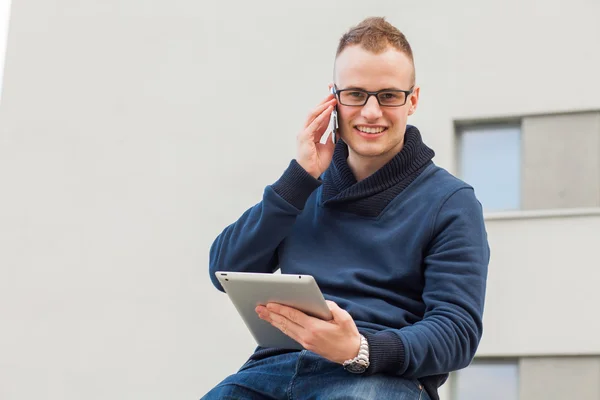 Stijlvolle man met Tablet PC- en mobiele telefoon — Stockfoto