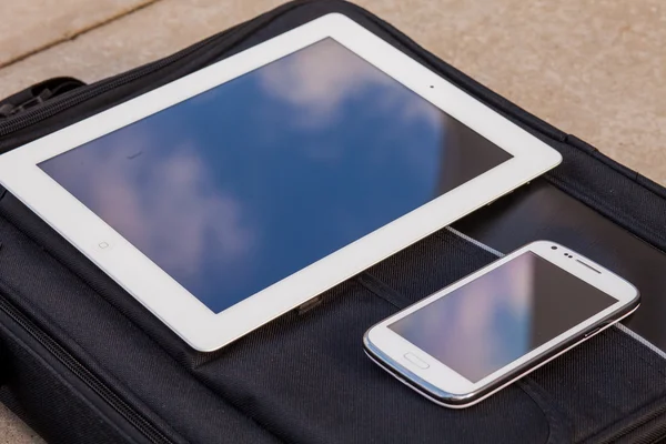 Tablet PC- en mobiele telefoon op een zak — Stockfoto