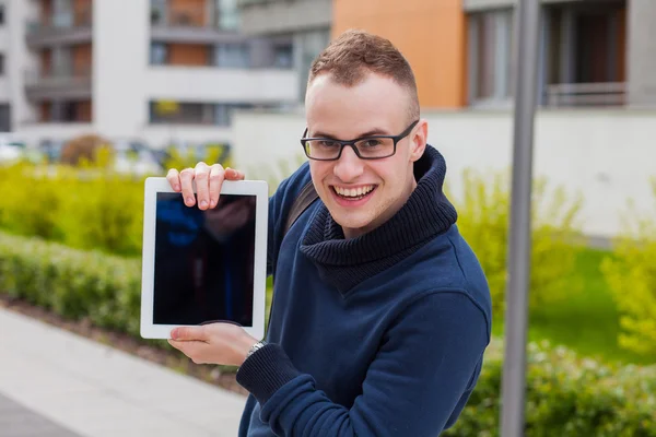 Młody człowiek z komputera typu tablet na ulicy — Zdjęcie stockowe