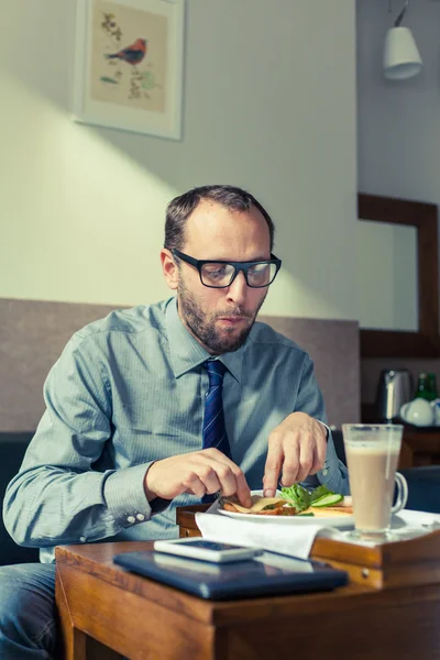 Businessman eating breakfast at home — Stock Photo, Image