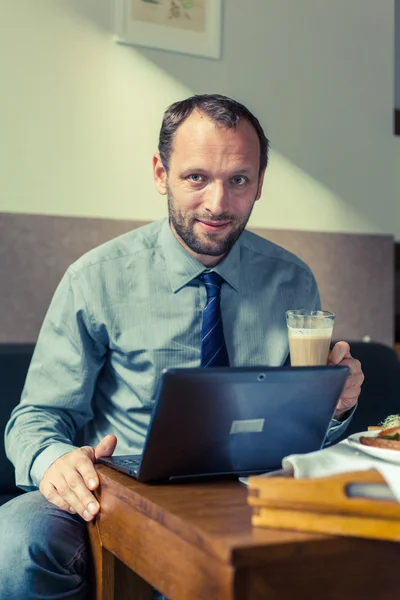 Businessman drinks coffee at hotel — Stock Photo, Image