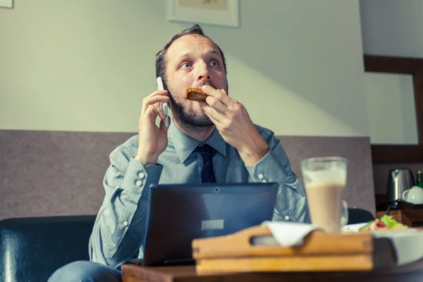 Mann benutzt Handy während des Frühstücks — Stockfoto