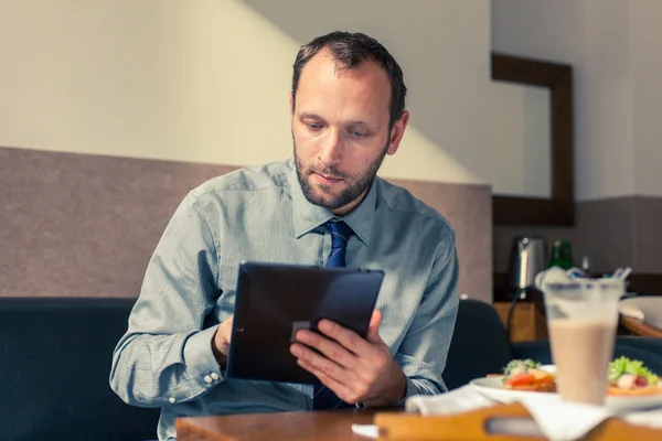 Zakenman werken op Tablet PC tijdens het ontbijt — Stockfoto