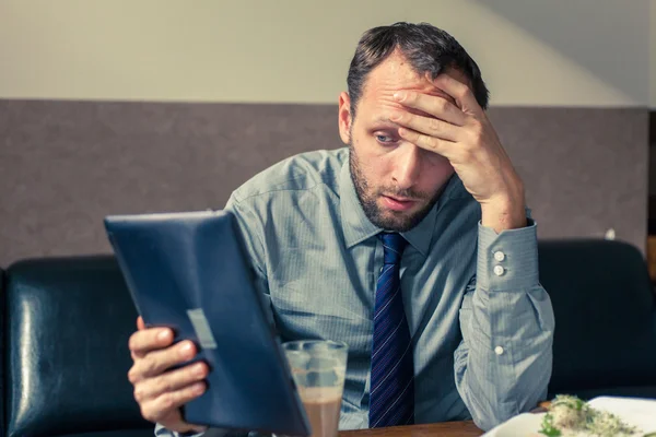 Geschäftsmann arbeitet beim Frühstück am Tablet — Stockfoto