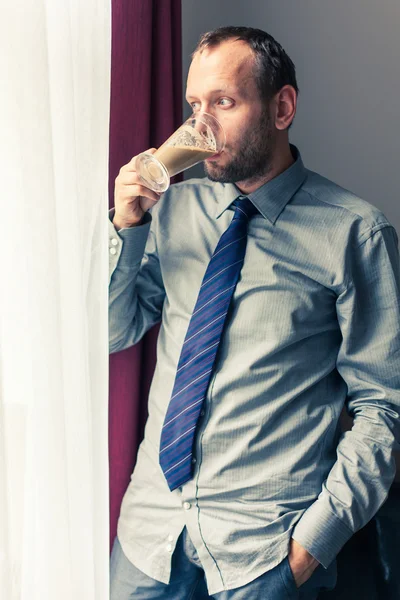 Businessman drinks coffee at hotel — Stock Photo, Image