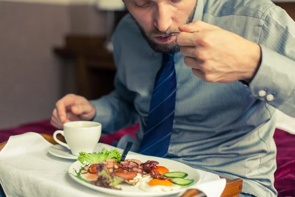 Businessman eating breakfast at home — Stock Photo, Image