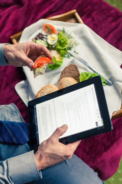 Affärsman som arbetar på tablett under frukosten — Stockfoto