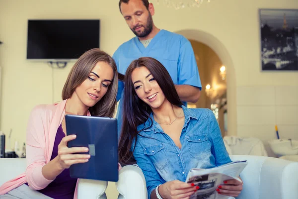 Freunde schauen im Friseursalon auf Tablet-PC — Stockfoto