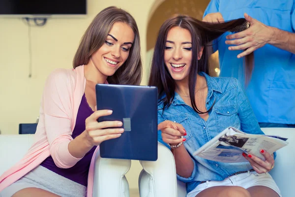 Freunde schauen im Friseursalon auf Tablet-PC — Stockfoto