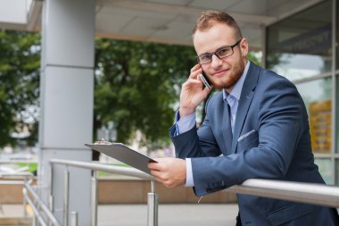 Cep telefonu ve tablet pc kullanarak iş adamı