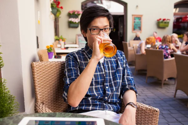 Asiatiska man dricker öl i café — Stockfoto