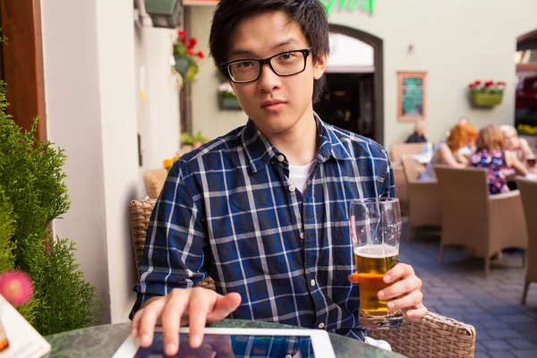 Man drinking beer and using tablet pc — Stock Photo, Image