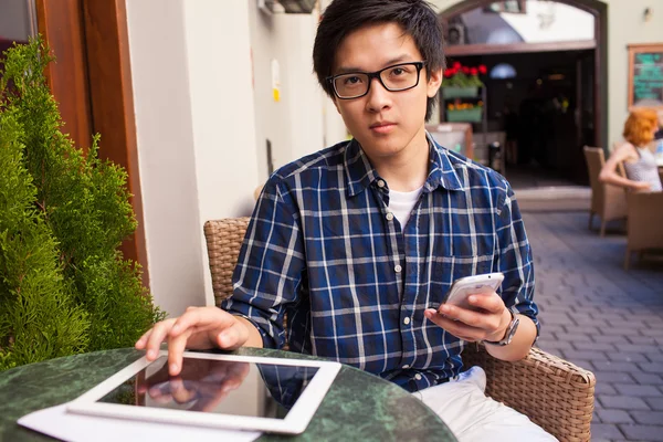 Студент с помощью планшетного ПК и смартфона — стоковое фото