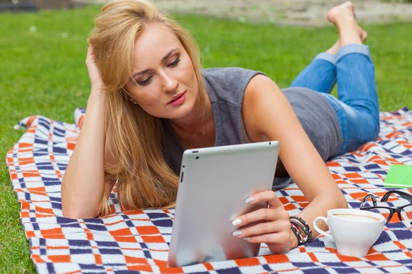 Frau benutzt Tablet-PC im Park — Stockfoto