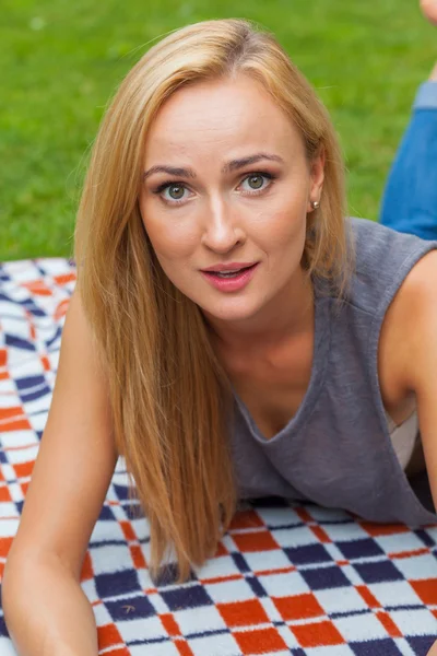 Blondine liegt auf Decke im Park — Stockfoto