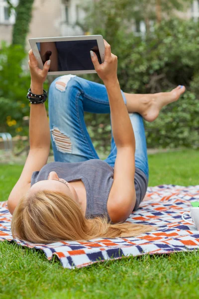 Kvinna med hjälp av TabletPC i park — Stockfoto