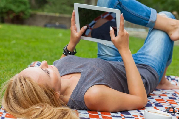 Kvinna med hjälp av TabletPC i park — Stockfoto