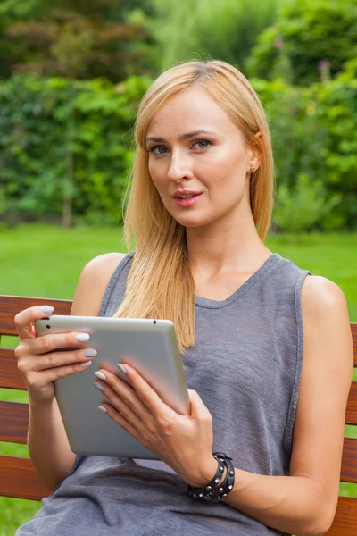 Frau benutzt Tablet-PC auf Holzbank — Stockfoto