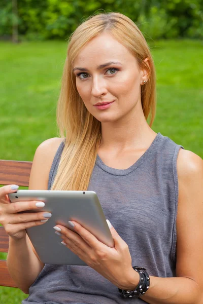 Frau benutzt Tablet-PC im Park — Stockfoto