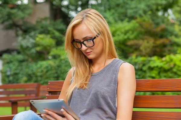 Vrouw die tablet pc gebruikt in park — Stockfoto