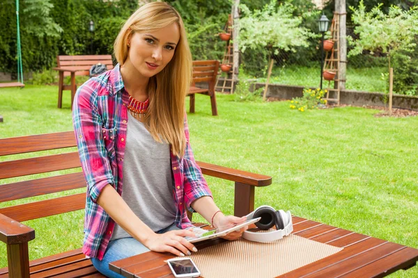 Frau benutzt Tablet-PC und hört Musik — Stockfoto