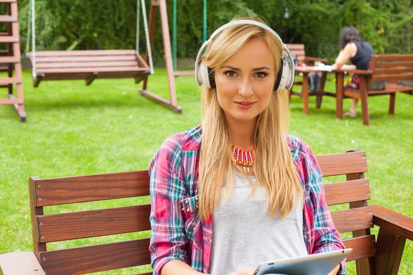 Frau benutzt Tablet-PC und hört Musik — Stockfoto