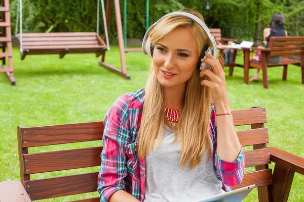 Frau benutzt Tablet-PC und hört Musik — Stockfoto